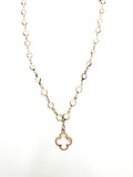 Gold necklace with a clover-shaped pendant on a white background