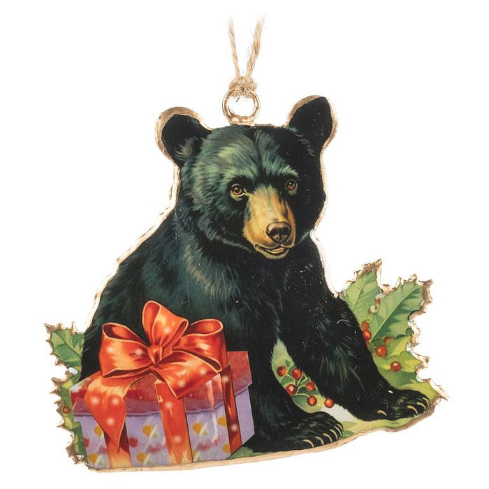 Decorative bear ornament with a gift and holly leaves on a white background