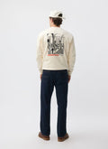 Rear view of a model wearing the Percival Bistro Printed Sweatshirt in ecru, showing the large back graphic.