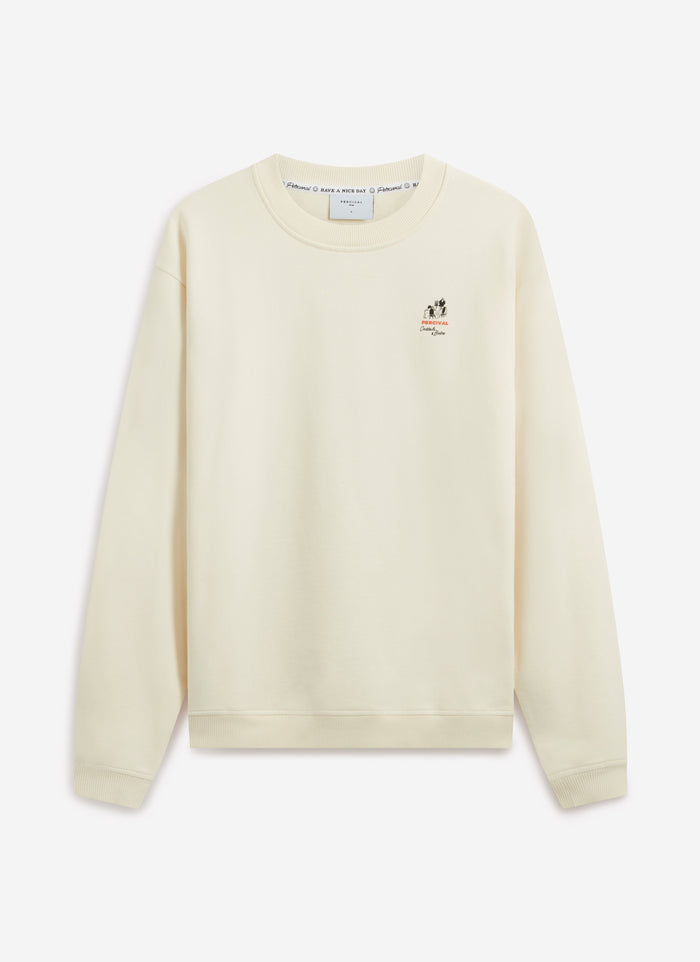 A model wears the Percival Bistro Printed Sweatshirt in ecru. Front-on studio shot showing the chest graphic and regular fit.