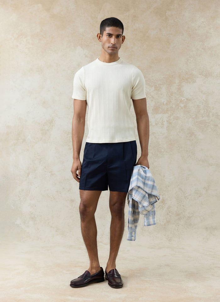 Percival navy cotton Blake double pleated shorts styled with a cream ribbed tee and dark leather loafers.