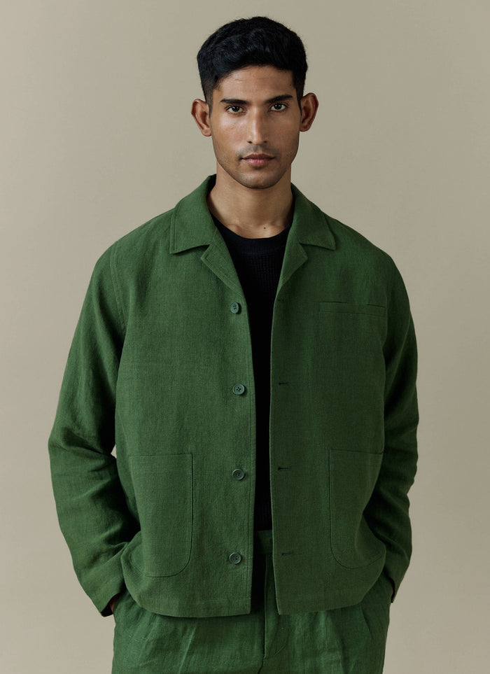 A model wears the Percival Linen Overshirt in Forest, styled with matching trousers and a black t-shirt.