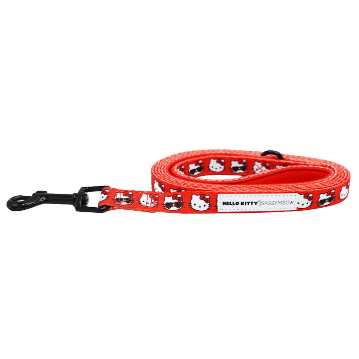 The Sassy Woof Cat Leash - Hello Kitty® Red Classic features a repeating Hello Kitty pattern, comfy neoprene handle, and sturdy black metal clasp. The label reads Hello Kitty | Sassy Woof.