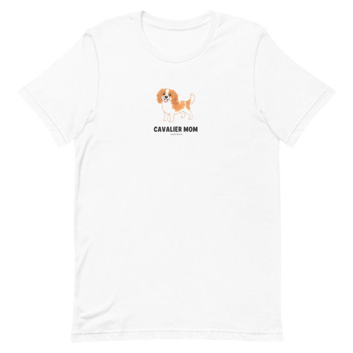The Sassy Woof Cavalier Mom Tee is a white unisex shirt with a brown and white Cavalier King Charles Spaniel illustration above “CAVALIER MOM” text—perfect for any proud dog mom.