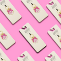 Sassy Woof Collar Tag - Mama's Girl (Gold) keychains, adorned with pink bows, are displayed on white cards over a bright pink background—ideal as playful dog collar tags or cute dog charms.