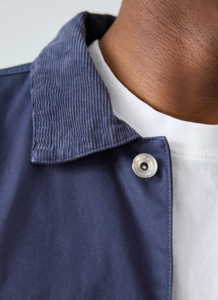 Close-up of a model wearing the navy Cord Collar Jacket from Champion x Percival collection, showing the corduroy detail.