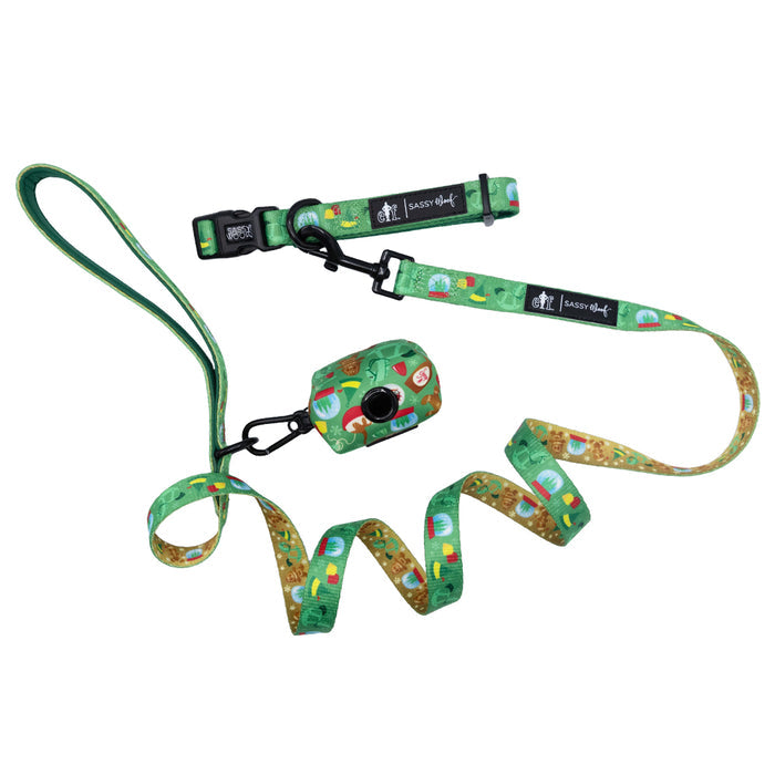 Sassy Woof’s Dog Collar Three Piece Bundle - Elf™ adds a festive flair with its green leash, collar, and waste bag holder, each showcasing playful cartoon designs and black clasps, beautifully displayed on a white background.