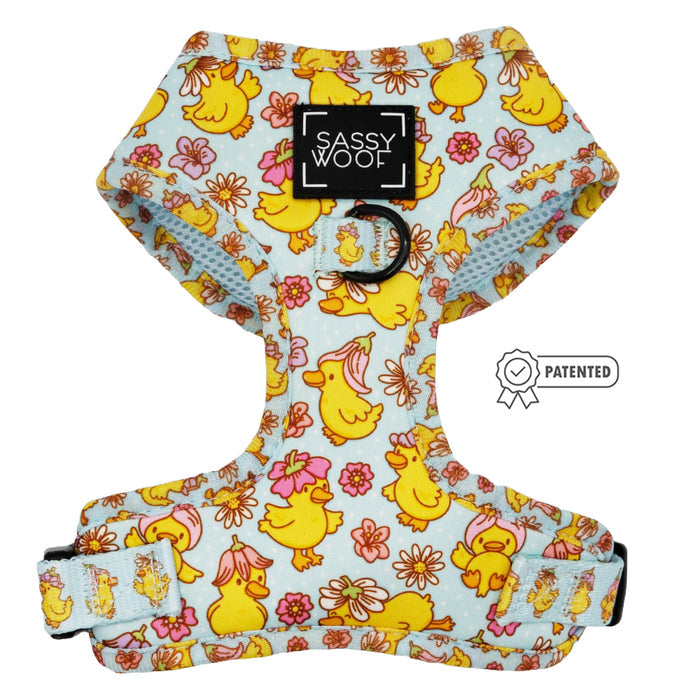 The Sassy Woof Dog Four Piece Bundle - Good Duck, Babe! features a light blue adjustable harness with yellow ducklings, pink flowers, orange accents, a black Sassy Woof label, and a Patented badge—ideal for your puppy's growth.