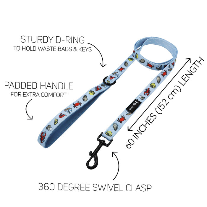 The Sassy Woof Dog Leash - Coastal Cuties features light blue cartoon designs, a padded handle, sturdy D-ring for bags or keys, 360° swivel clasp, and is 60” long—pair with the matching adjustable harness!.