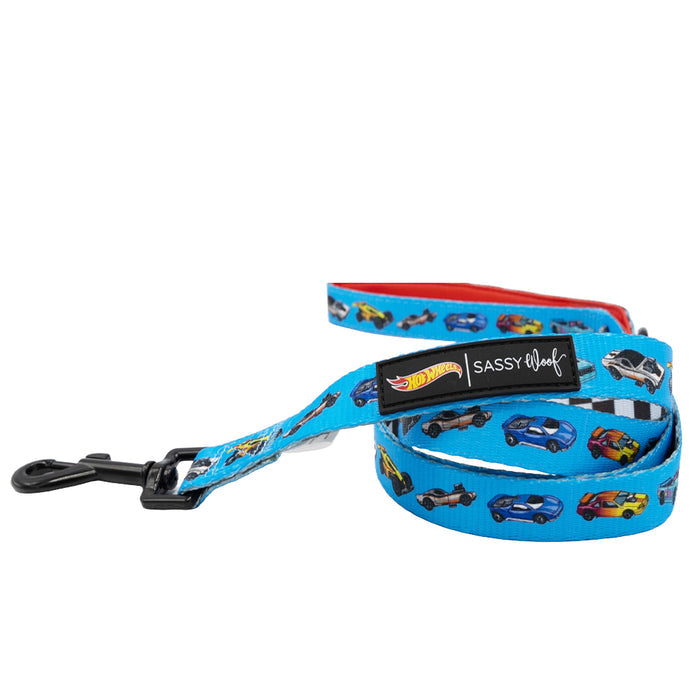 The Sassy Woof Dog Leash - Hot Wheels™ is a blue leash with colorful cartoon cars, a black metal clasp, and a black Sassy Woof tag with the Hot Wheels™ logo—ideal for fans of racing-inspired pet accessories.