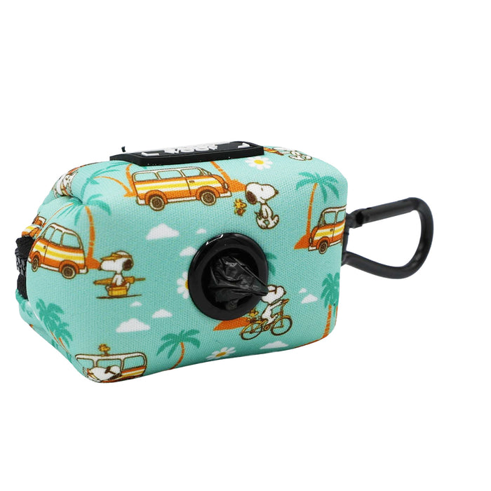The Sassy Woof Dog Waste Bag Holder - Peanuts™ Road Tripping features a teal neoprene design with Snoopy, surfboards, palm trees, and yellow vans, plus a black clip and front bag opening—ideal for dog walks.