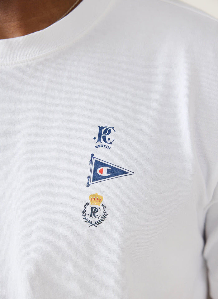 A close-up of the collaboration logos on the chest of the white Flag T-shirt from Champion x Percival.