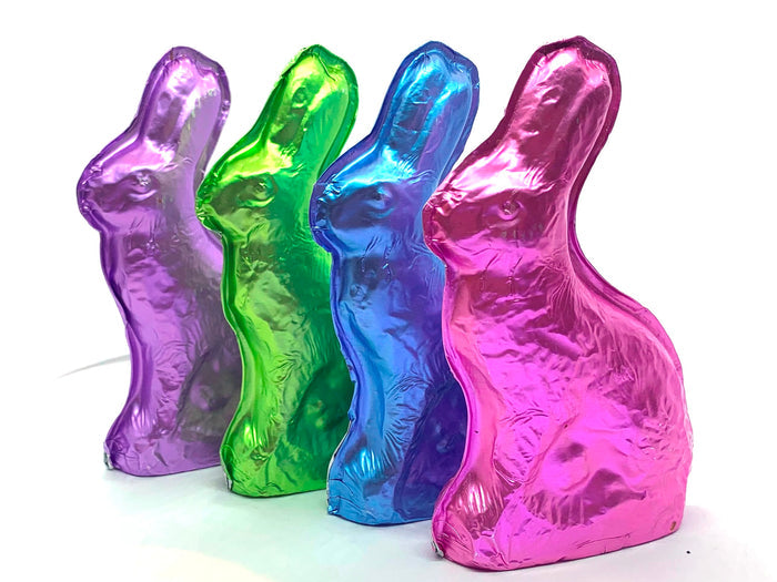 Molded chocolate bunnies are wrapped in pink, blue, green or purple foil.