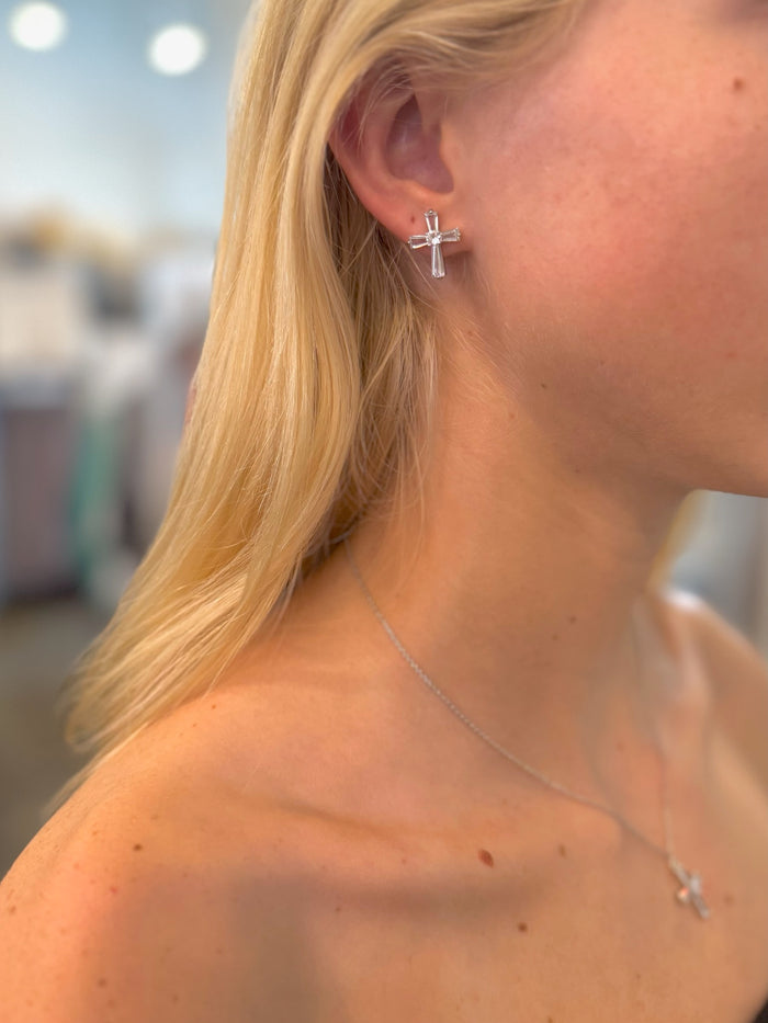 Grace Cross Studs in silver with baguette-style crystals on models ear