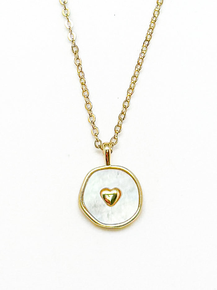 Necklace with a gold chain and pendant featuring a gold heart design on a white background