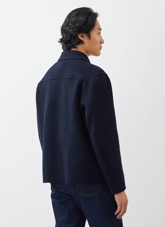 Side-back view of a model wearing the Percival Heavy Wool Overshirt in navy, highlighting its classic boxy fit.