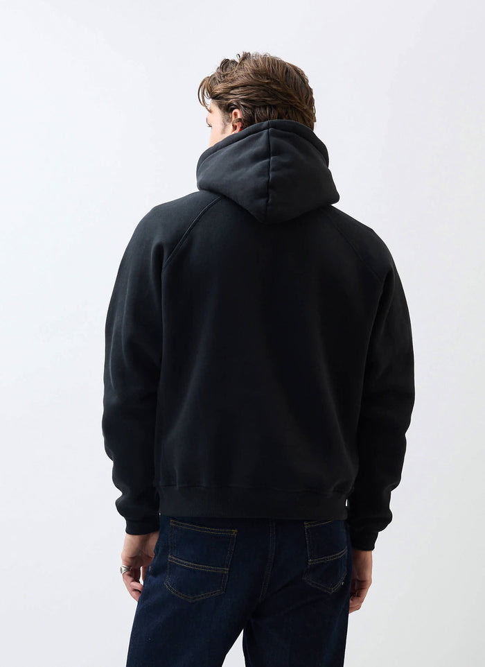 The back of a model wearing the black Percival Heritage 90's Hoodie, showing the classic raglan sleeve design.