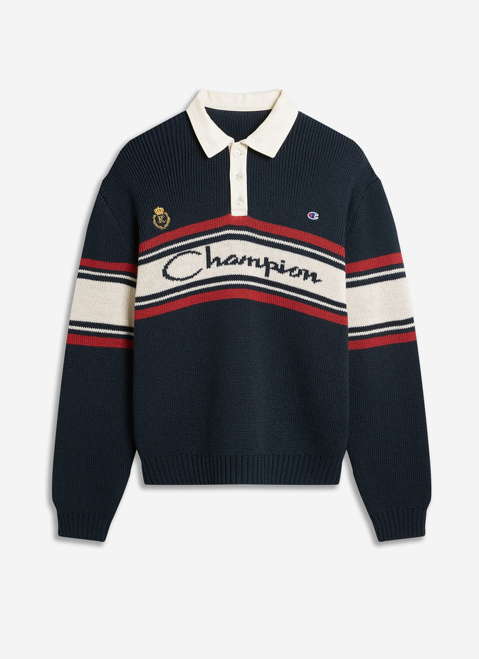 The Champion x Percival Jacquard Knitted Rugby Shirt in navy, shot flat to show its contrast collar and striped branding.