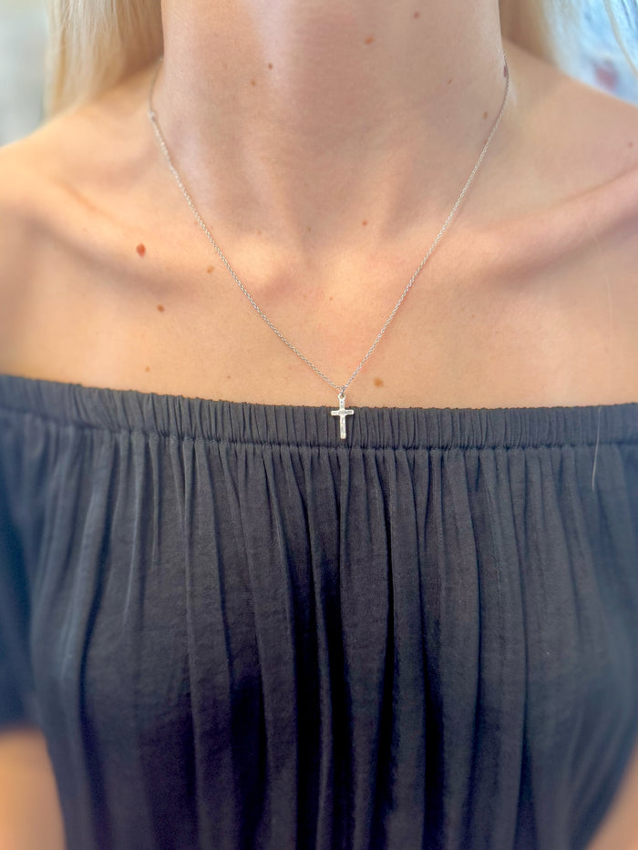 Juliette Cross Necklace in silver on delicate chain on woman's neck