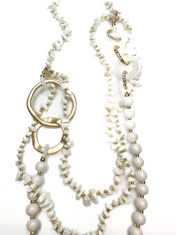 Pearl and gold beaded necklace on a white background