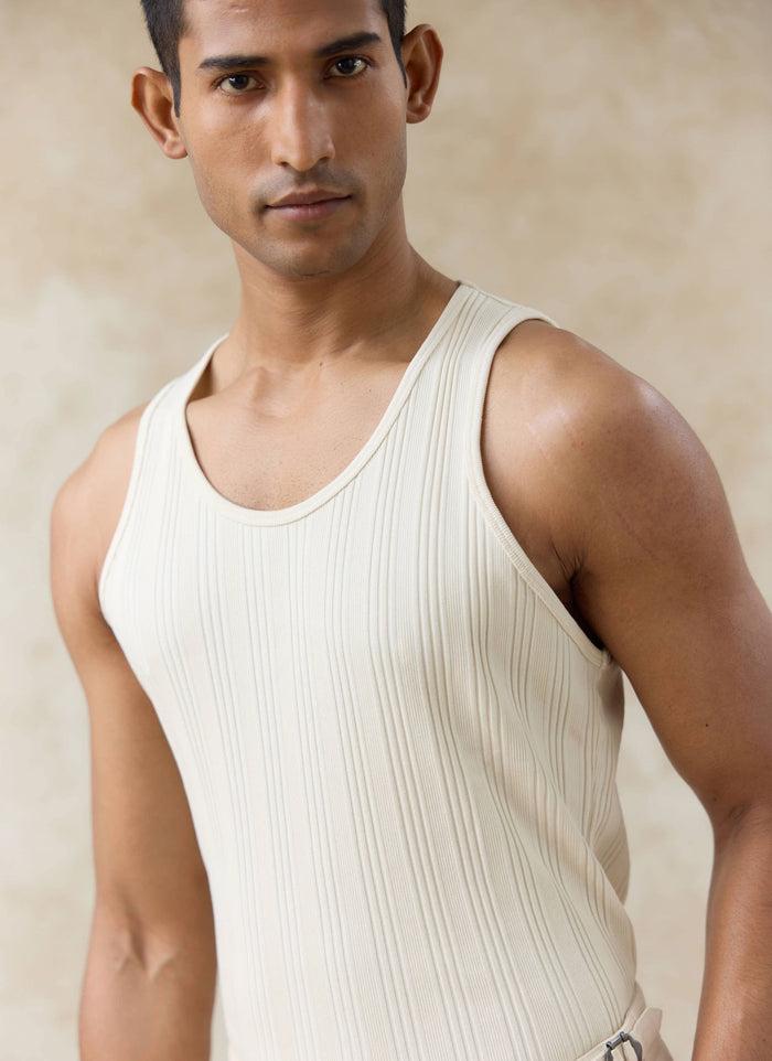 Model wearing the cream-coloured Percival Leon Ribbed Vest, featuring organic cotton jersey and a classic scoop neck.