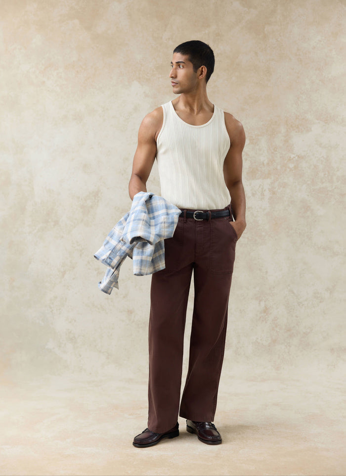 Percival Lungo herringbone straight trousers in espresso brown styled with a cream Leon ribbed vest.