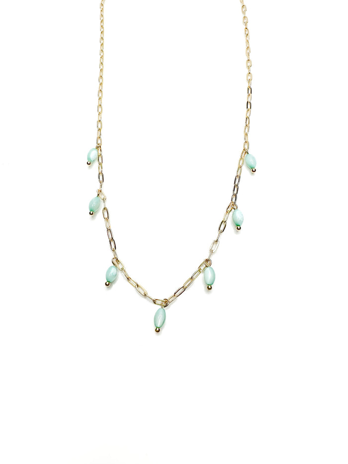 Delicate gold chain necklace with seafoam green bead drops laid flat on a white background
