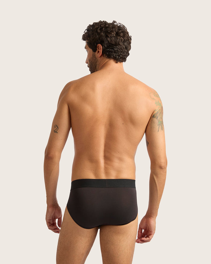 Man wearing a black underwear on a plain background