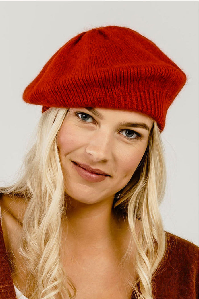 A woman wearing a red Merinosilk beret hat.