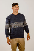 Man wearing a navy sweater with patterned sleeves against a plain background