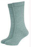A pair of green Merinosilk plain socks, displaying the side profile of the socks with visible ribbed texture.