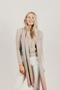 A woman wearing a Kapeka town scarf merino silk blushpink