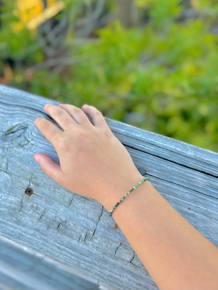 Nora Epidote Beaded Bracelet in Green and gold shown on model's wrist