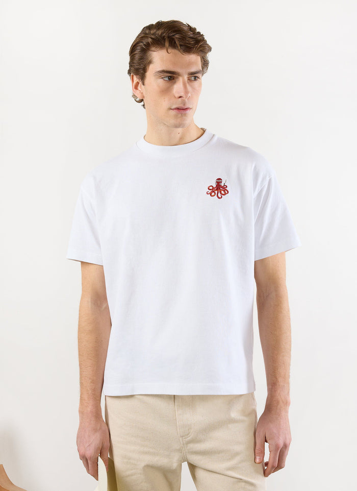 A model wears the white Percival Octo Oversized T-shirt, which features a red embroidered octopus sushi chef on the chest.