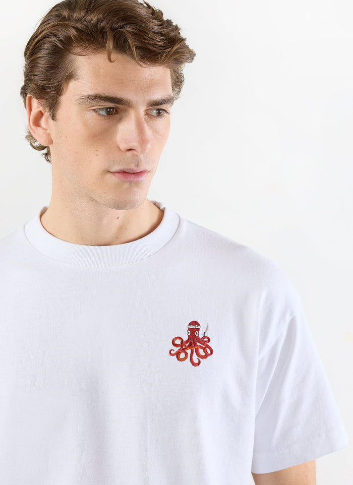 Close-up of a model wearing the Percival Octo Oversized T-Shirt in white, featuring the red embroidered octopus sushi chef.