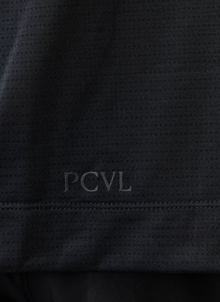 A close-up of the tonal PCVL logo on the black recycled technical jersey of the Percival Performance Vest.
