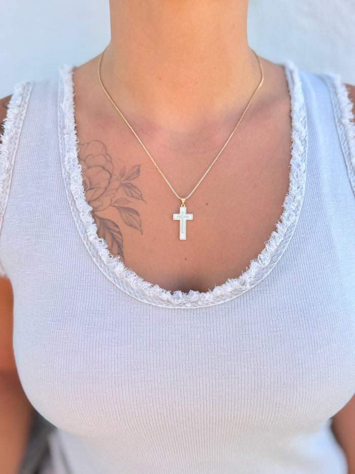 Perla Cross Necklace with gold chain and mother-of-pearl cross pendant being worn.