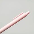 Pink pen with 'love' engraving on a light gray background