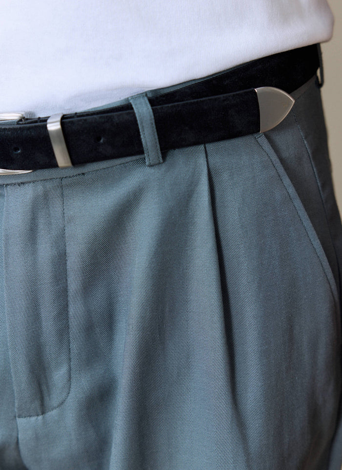A close-up of the Percival Pleated Leg Trousers in slate blue, showing the fabric texture and pleat detail at the waist.