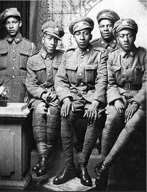 Black and white photograph of five soldiers from the No. 2 Black Battalion in uniform sitting together.