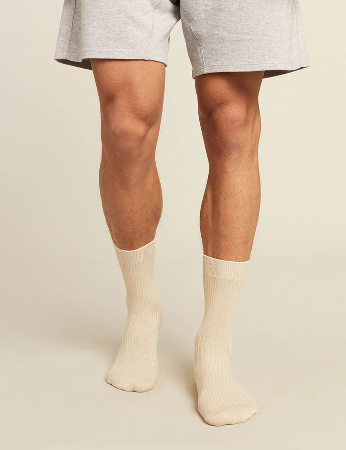 Person wearing beige socks on a plain background