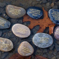 Decorative stones with engraved text on a rocky surface