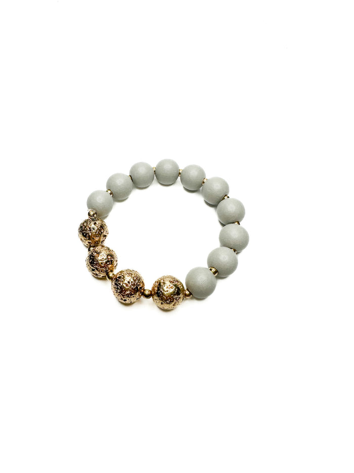 Bracelet with gold and white beads on a white background