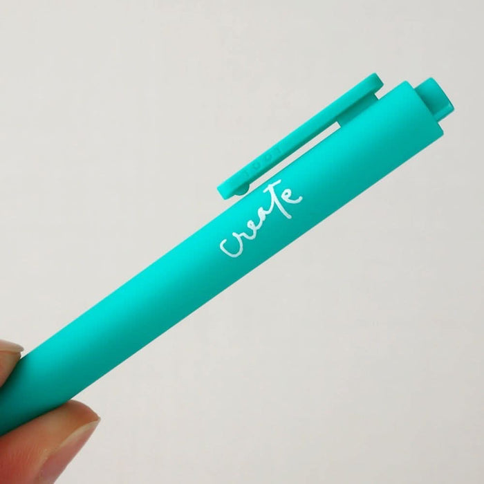 Teal pen with 'create' written on it against a light gray background