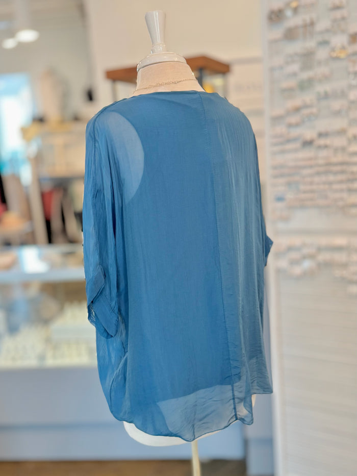 Blue blouse on a mannequin against a blurred indoor background