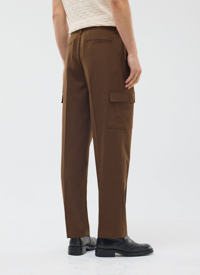 A model seen from the back and side, wearing the Percival Trentino Tailored Patch Pocket Trouser in brown.