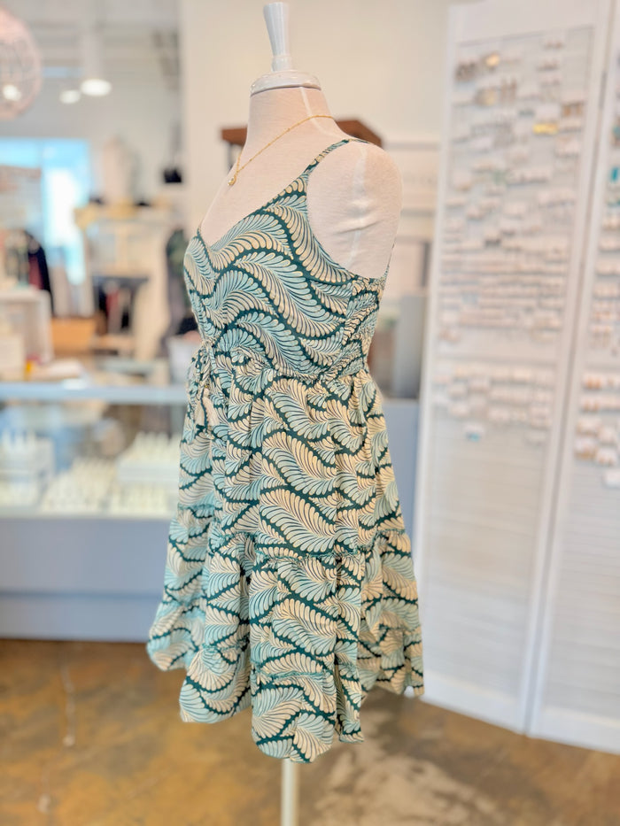 Side view of the Dress showing its slowly tiered skirt and lightweight basic with green leaf print