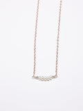 Rose gold chain necklace featuring a horizontal row of five small white pearls, spaced with silver accents, displayed on a white background.