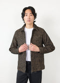 A model wears the Percival Zip Overshirt in Oak Twill, a brown and black patterned jacket, open over a white t-shirt.